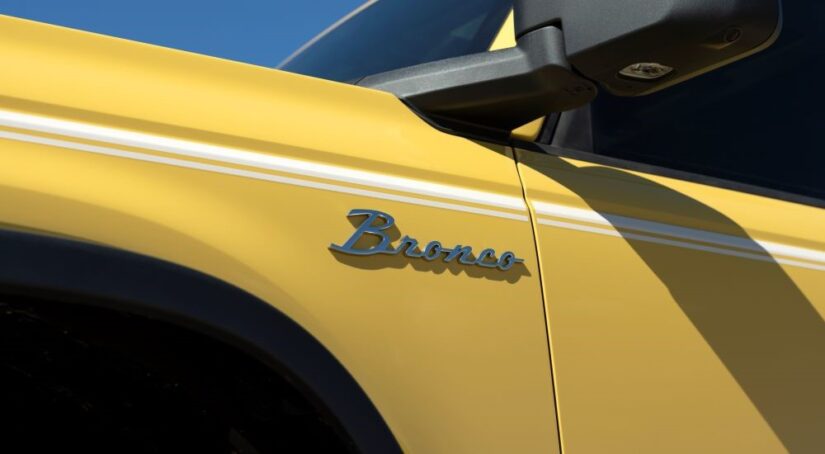 A close-up on the badge of a yellow 2024 Ford Bronco Heritage is shown.