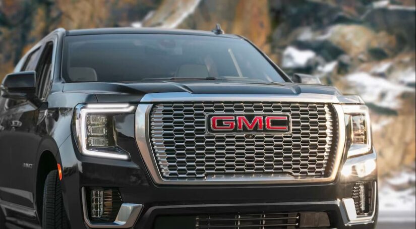 A close-up on the grille of a black 2024 GMC Yukon Denali is shown after visiting a Fayetteville GMC dealer.