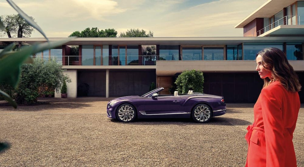 A person is shown standing near a purple 2024 Bentley Continental GTC Mulliner.