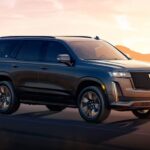 A black 2024 Cadillac Escalade is shown driving.