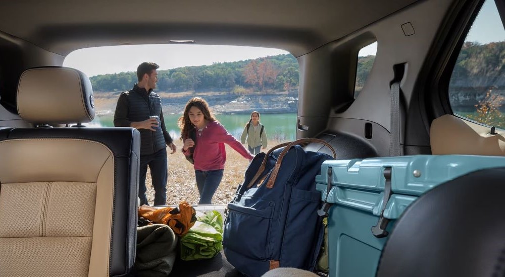 A family is shown offloading bags from the back of a 2024 Chevy Equinox.