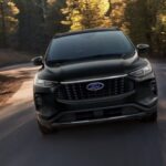 A black 2024 Ford Escape is shown driving.