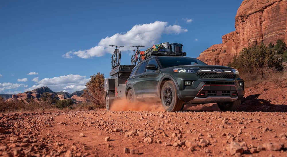 A dark green 2024 Ford Explorer Timberline is shown driving in a desert.