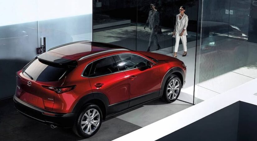 A person is shown walking near a red 2024 Mazda CX-30.