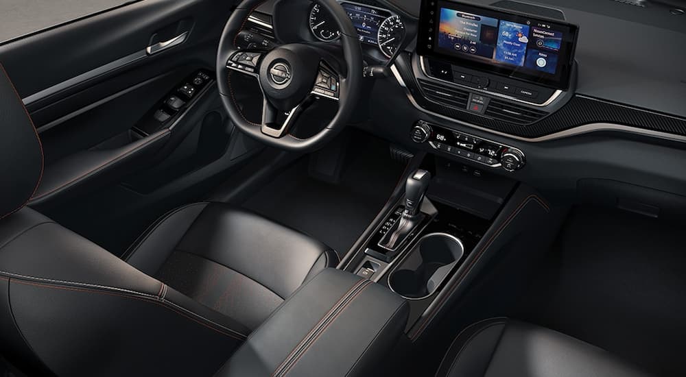 The black interior, steering wheel, and dash of a 2024 Nissan Altima.