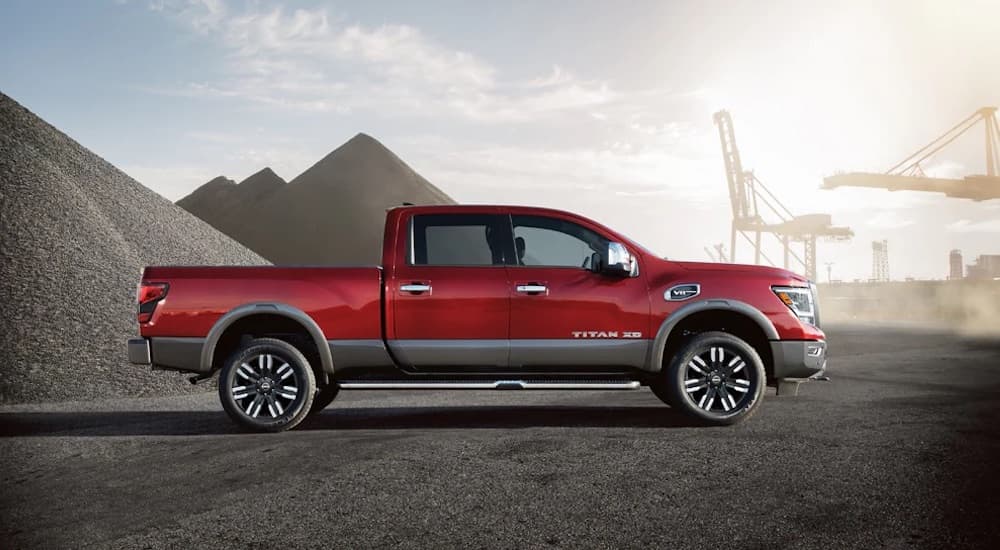 A red 2024 Nissan Titan XD is shown parked from the side.