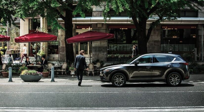 A gray 2019 Mazda CX-5 is shown parked near a cafe.