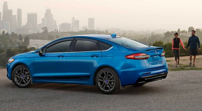 One of the available CPO Fords for sale, a blue 2020 Ford Fusion, is shown parked.