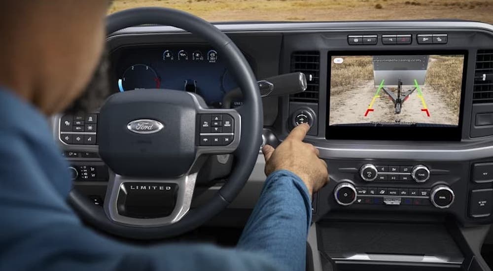 A person is shown interacting with the dashboard in the interior of a 2024 Ford F-350.