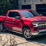 A red 2024 Chevy Silverado 1500 Z71 is shown parked on a driveway after visiting a Chevy dealer.