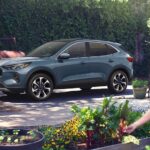 A dark blue 2024 Ford Escape Platinum is shown parked in a driveway.