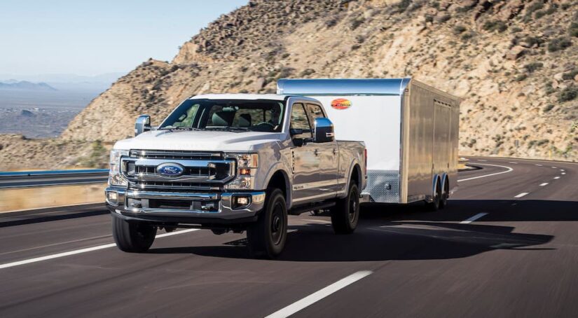 A white 2024 Ford F-350 XLT is shown towing a trailer.