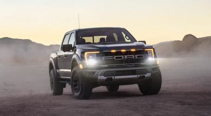 A silver 2024 Ford F-150 Raptor is shown parked off-road after visiting a Ford dealer.