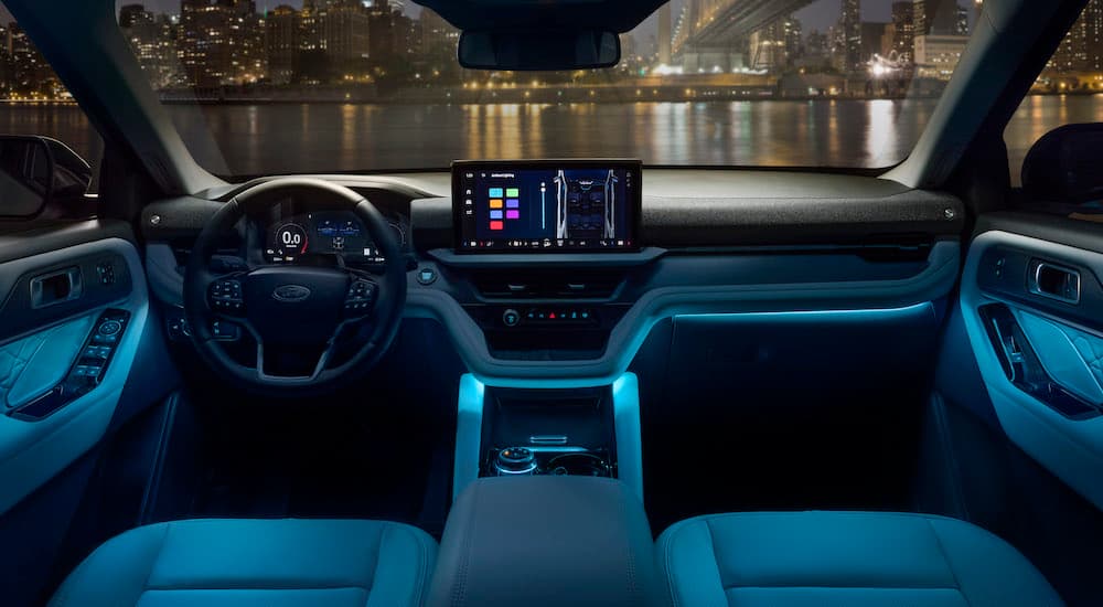 The blue-lit interior of a 2025 Ford Explorer Platinum is shown from above the center console.