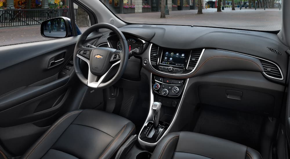 The front seats and dashboard in a black interior 2020 Chevy Trax.
