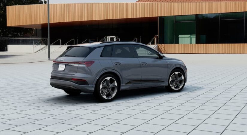 A gray 2024 Audi Q4 e-tron is shown parked near a building.