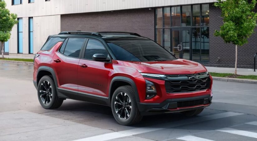 A red 2025 Chevy Equinox is shown driving in a city after visiting a Chevy dealer.