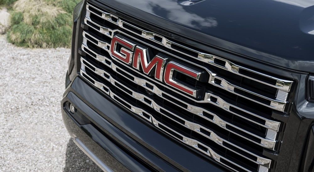 A close-up on the front grille of a black 2024 GMC Canyon is shown.