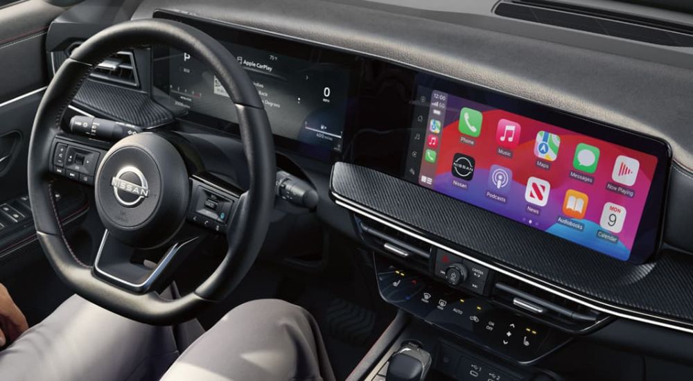 A close up shows the steering wheel and infotainment screen in a 2025 Nissan Kicks.