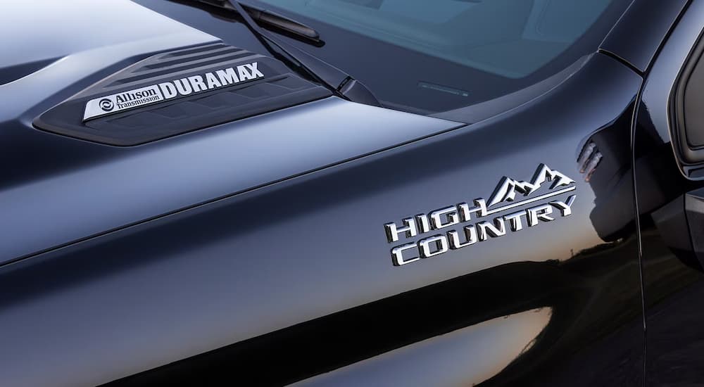 A close-up of the Allison Transmission, Duramax Engine, and High Country badging on a black 2024 Chevy Silverado HD.