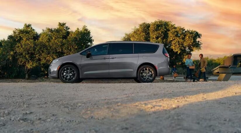 A gray 2024 Chrysler Pacifica is shown parked near a picnic bench.