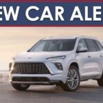 A New Car Alert banner is shown above a white 2025 Buick Enclave parked near a beach.