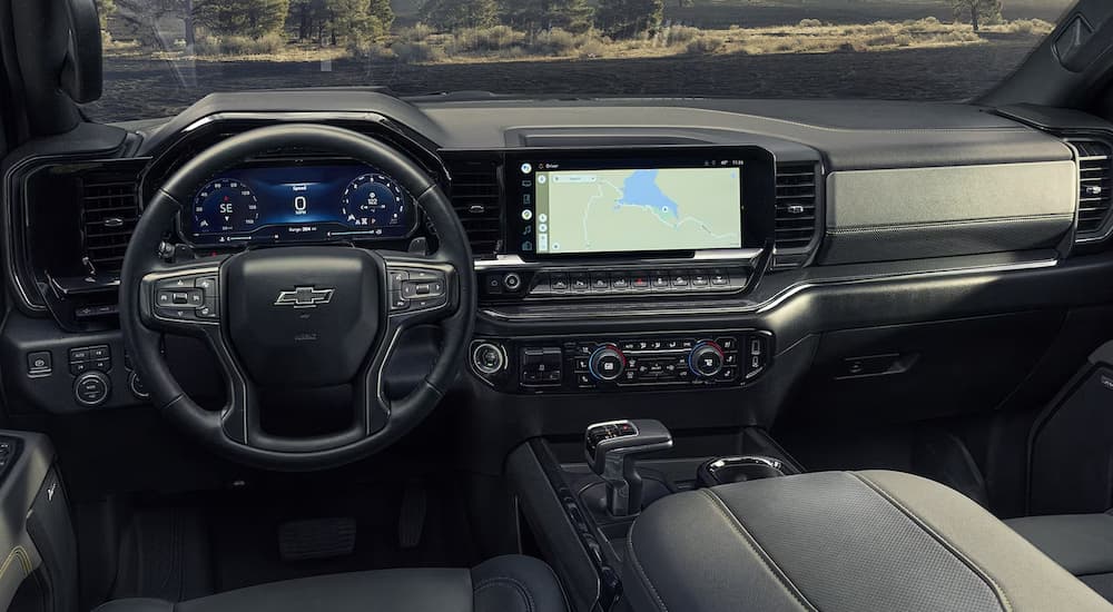 The steering wheel and infotainment screen in a 2024 Chevy Silverado 1500 at a Chevy dealership.
