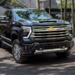 A black 2024 Chevy Silverado HD parked in a residential driveway.