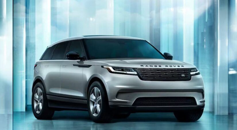 A silver 2024 Range Rover Velar is shown parked in a blue room.
