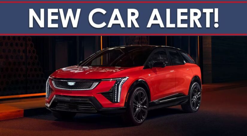 A new car alert banner is shown above a red 2025 Cadillac OPTIQ.