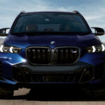 A blue 2025 BMW X5 M60i is shown from the front.