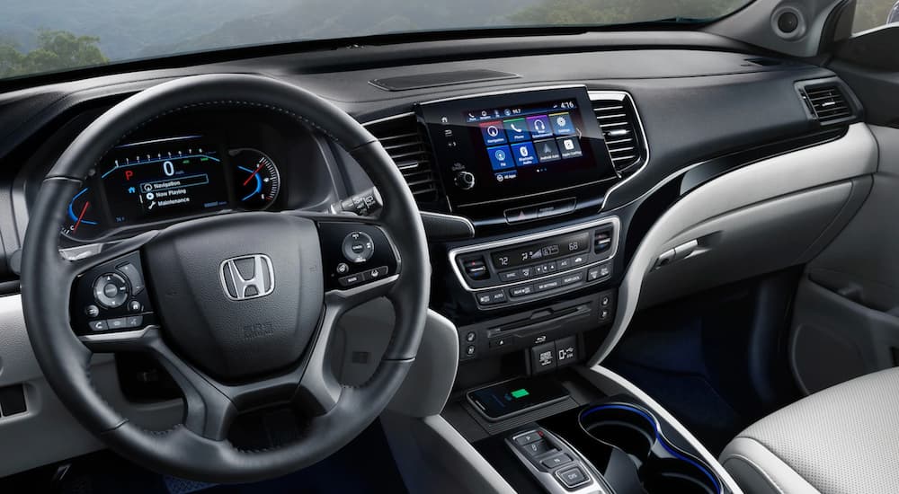 The black and grey 2020 Honda Pilot center console and steering wheel.