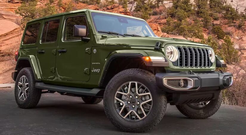 A green 2024 Jeep Wrangler Sahara for sale is parked in an open lot.