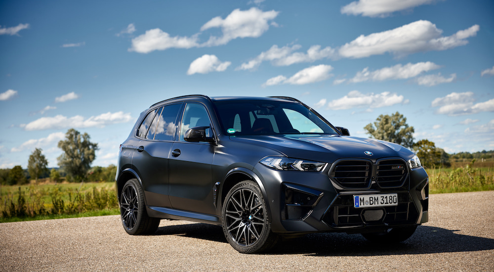A grey 2024 BMW X5 M Competition is shown from the front at an angle after leaving a BMW dealer.