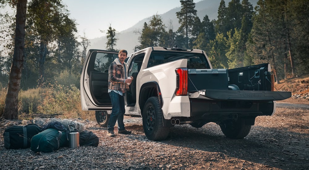A man is shown unloading camping supplies from a 2024 Toyota Tundra TRD after leaving a Toyota dealer.