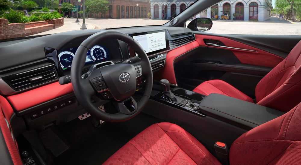 The red and black interior is shown in a 2025 Toyota Camry.