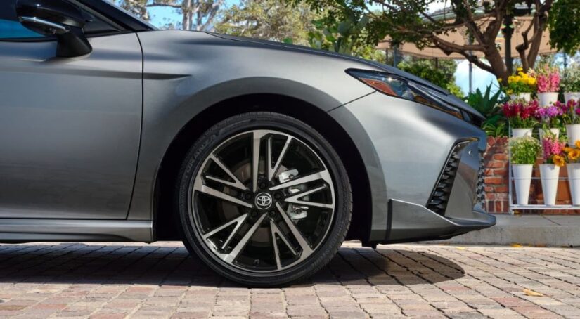A close up shows a wheel on a silver 2025 Toyota Camry for sale.