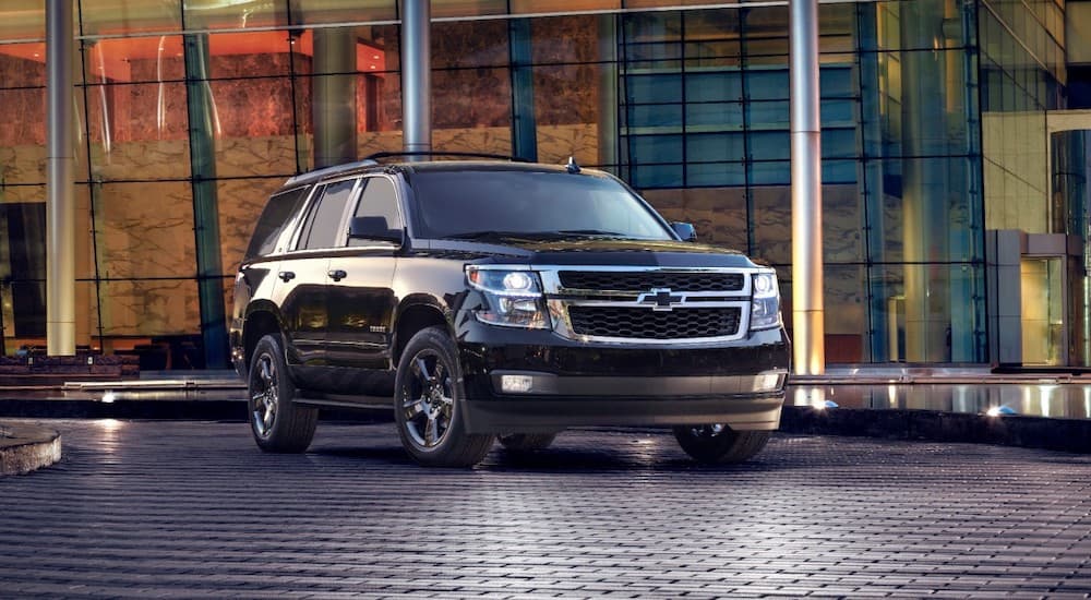 A black 2017 Chevy Tahoe is shown from the front at an angle after leaving a dealer that has used SUVs for sale.