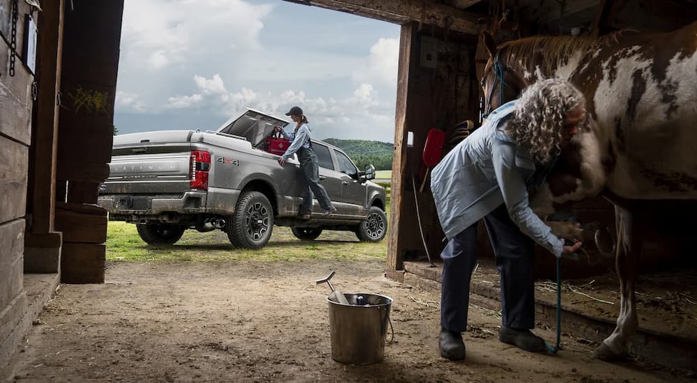 A silver 2024 Ford F-350 Super Duty parked outside of a barn.