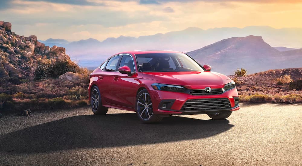 A red 2023 Honda Civic Touring parked by a canyon.