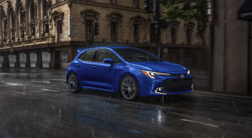 A blue 2024 Toyota Corolla XSE Hatchback driving in the rain