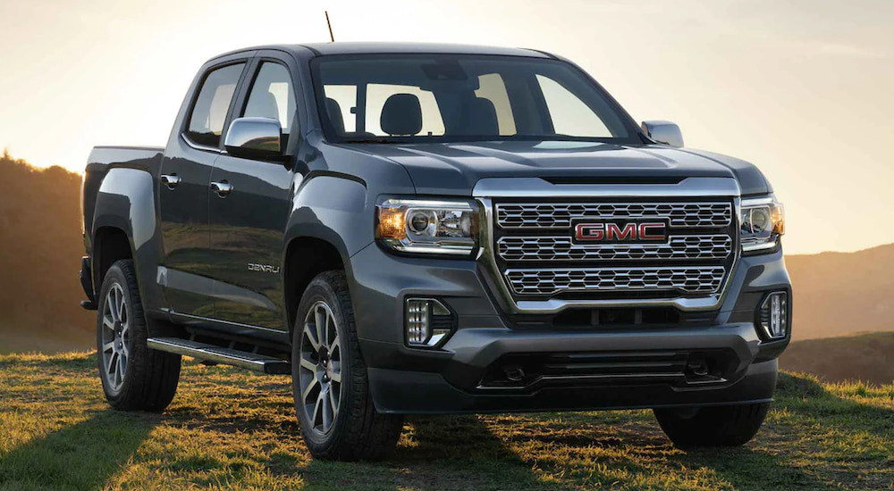 A dark grey 2022 GMC Canyon Denali parked on a grassy hilltop.