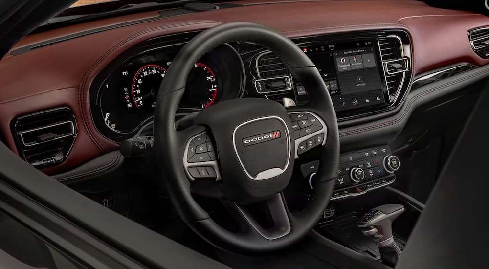 The red interior of a 2024 Dodge Durango is shown from the driver's window after leaving a Dodge dealer.