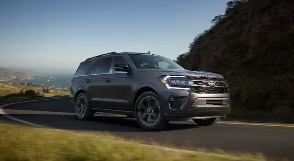 A gray 2024 Ford Expedition Platinum MAX is shown driving to a Ford dealer.