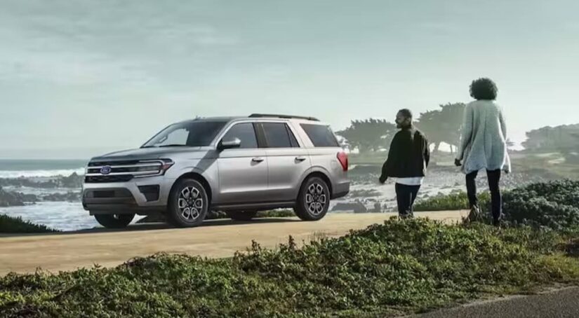 A silver 2024 Ford Expedition XLT MAX is shown parked near an ocean.