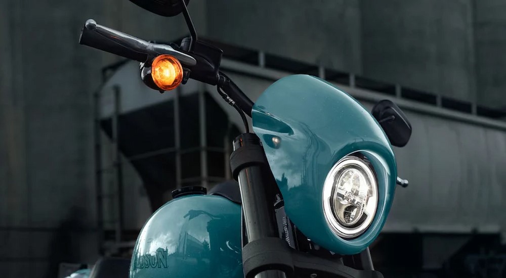 A close-up of the headlight on a blue 2024 Harley-Davidson Low Rider S is shown.