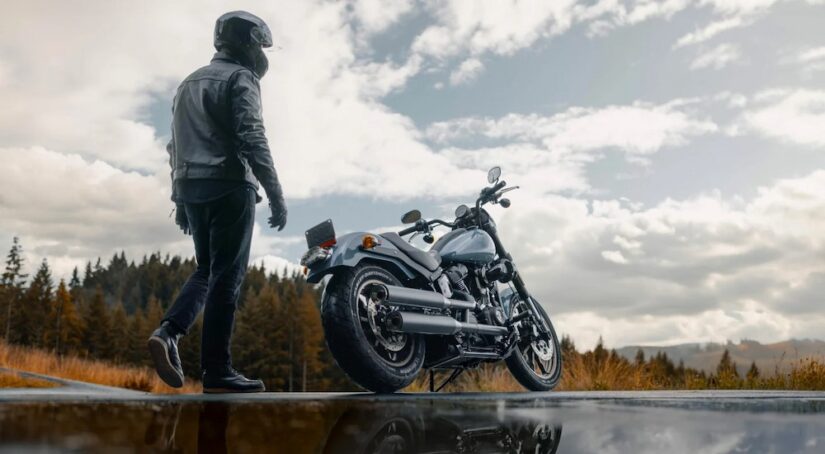 A person is shown walking towards a blue 2024 Harley-Davidson Low Rider for sale.