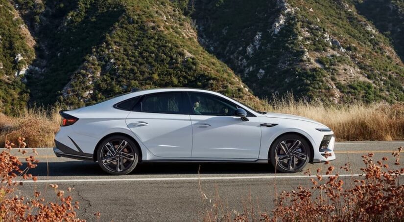 A popular Hyundai Sonata for sale. a white 2024 Hyundai Sonata N Line, is shown driving on a highway.