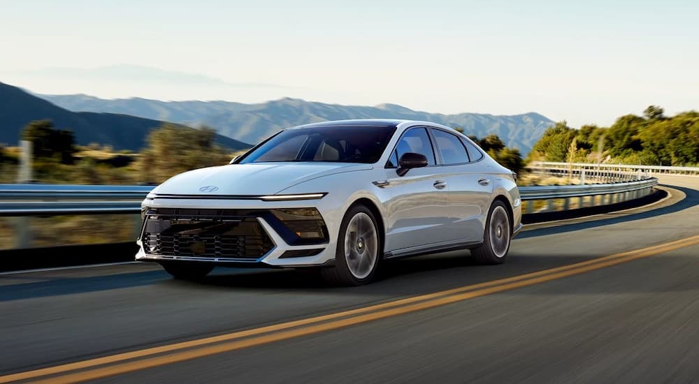 A white 2024 Hyundai Sonata N Line is shown driving on a highway.