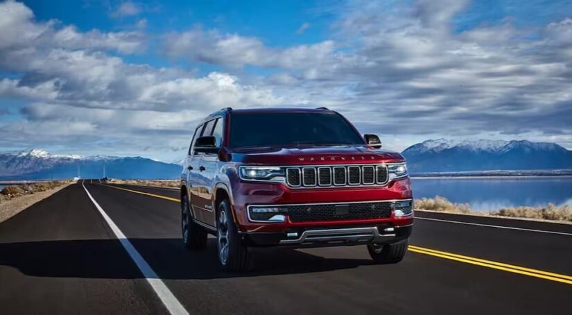 A red 2024 Jeep Wagoneer is shown driving to visit a Jeep dealer.